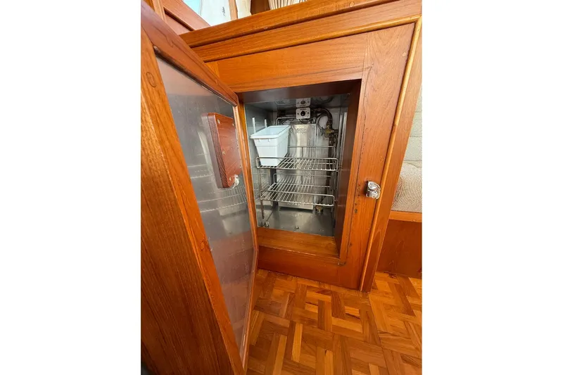 Margo Yacht Photos Pics Wooden cabinet with open door revealing interior shelves on a 1996 Grand Banks 42 Classic.