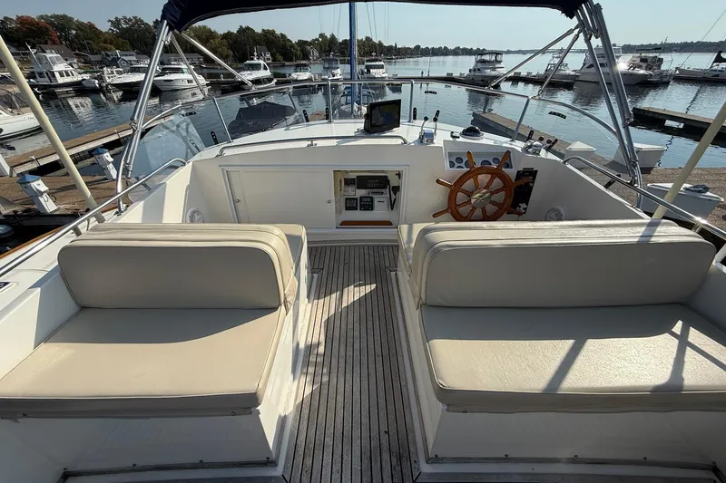 Margo Yacht Photos Pics 1996 Grand Banks 42 Classic yacht helm with wooden wheel and seating at marina.