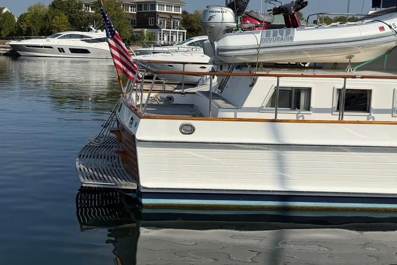 Margo Yacht Photos Pics 1996 Grand Banks 42 Classic yacht docked, featuring American flag and inflatable boat on deck.