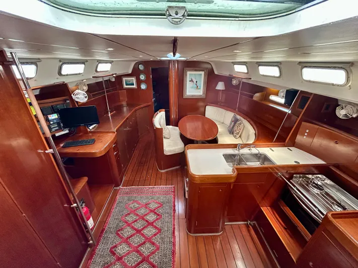 Blue Moon Yacht Photos Pics Luxurious interior of 2003 Beneteau First 47.7 yacht with wood finish and modern amenities.