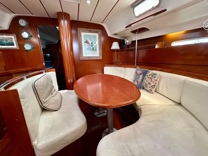 Blue Moon Yacht Photos Pics Interior of 2003 Beneteau First 47.7 yacht with cozy seating and wooden table.