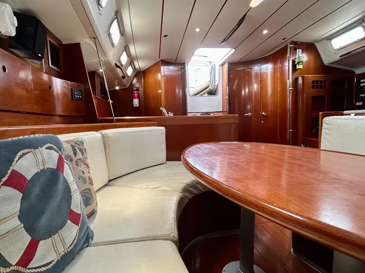 Blue Moon Yacht Photos Pics Luxurious interior of 2003 Beneteau First 47.7 yacht with wooden finishes and cozy seating.