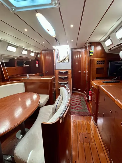 Blue Moon Yacht Photos Pics Interior of 2003 Beneteau First 47.7 yacht, featuring wood finishes and cozy seating.