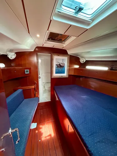Blue Moon Yacht Photos Pics Interior of 2003 Beneteau First 47.7 yacht with wooden finish and blue upholstery.