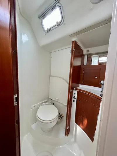 Blue Moon Yacht Photos Pics Beneteau First 47.7 2003 yacht bathroom with wooden cabinetry and compact design.