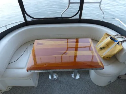  Yacht Photos Pics 2001 Cruisers Yachts 4450 Express Motoryacht interior with polished wood table and seating.