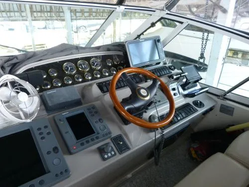  Yacht Photos Pics 2001 Cruisers Yachts 4450 Express Motoryacht helm with navigation instruments and wooden steering wheel.