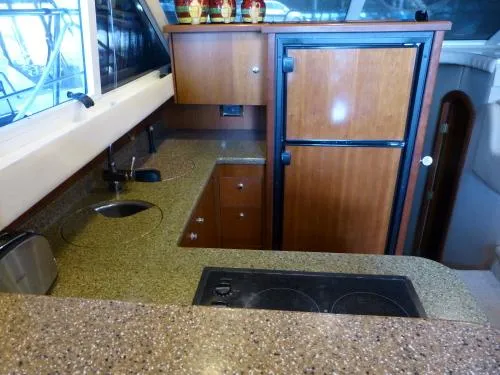  Yacht Photos Pics 2001 Cruisers Yachts 4450 Express Motoryacht kitchen with stove, sink, and fridge.