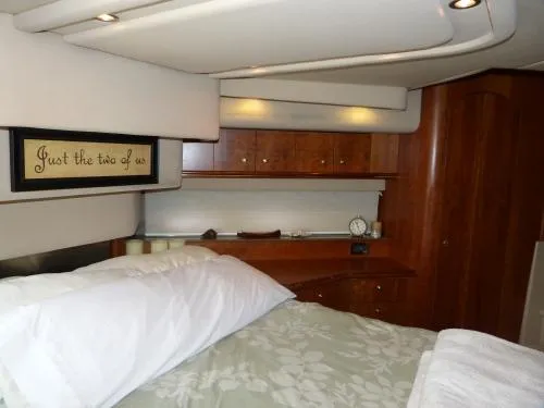  Yacht Photos Pics 2001 Cruisers Yachts 4450 Express Motoryacht bedroom with wood cabinetry and cozy bedding.