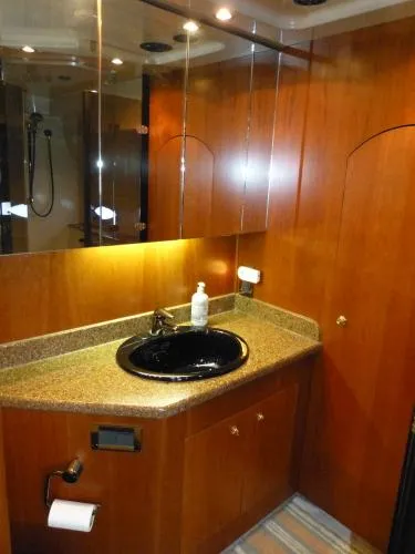  Yacht Photos Pics Luxurious bathroom in 2001 Cruisers Yachts 4450 Express Motoryacht with wood cabinetry and black sink.