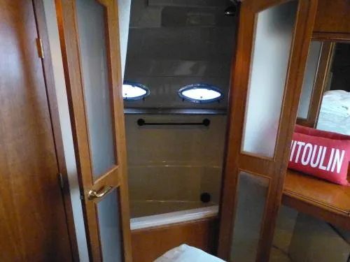  Yacht Photos Pics 2001 Cruisers Yachts 4450 Express Motoryacht bathroom with wooden doors and porthole windows.