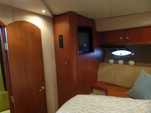 Yacht Photos Pics Interior of 2001 Cruisers Yachts 4450 Express Motoryacht cabin with wood paneling and cozy bed.