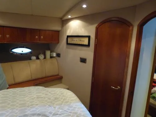  Yacht Photos Pics 2001 Cruisers Yachts 4450 Express Motoryacht interior cabin with bed and wooden accents.