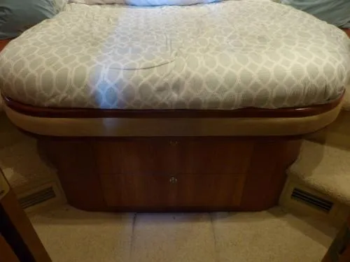  Yacht Photos Pics 2001 Cruisers Yachts 4450 Express Motoryacht interior cabin with bed and wooden storage.