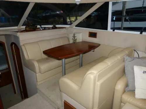  Yacht Photos Pics 2001 Cruisers Yachts 4450 Express Motoryacht interior with beige seating and wooden table.