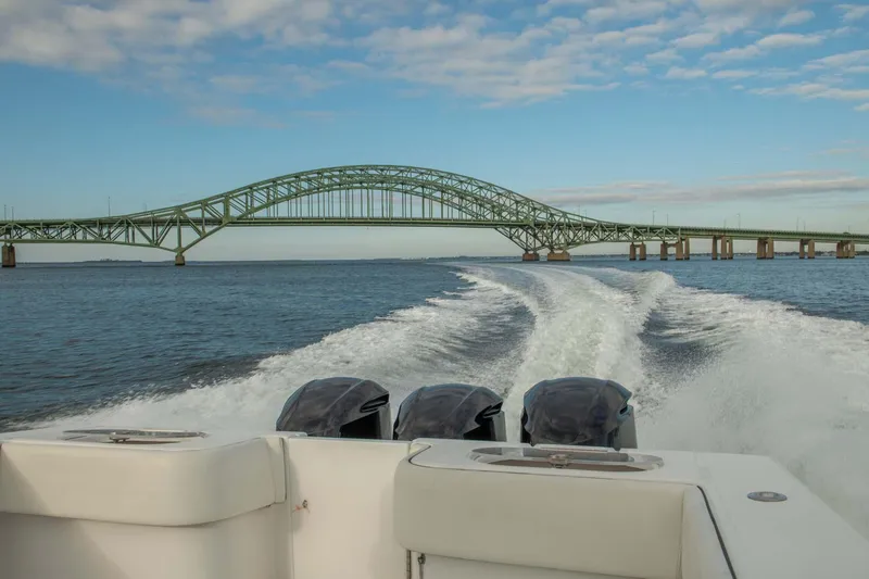 Mr Fish Yacht Photos Pics SeaHunter 35 Tournament boat cruising under a bridge, 2016 model, scenic water view.