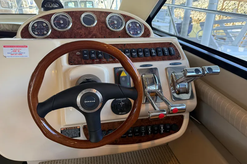  Yacht Photos Pics 2005 Meridian 341 Sedan helm with wood steering wheel and control panel.