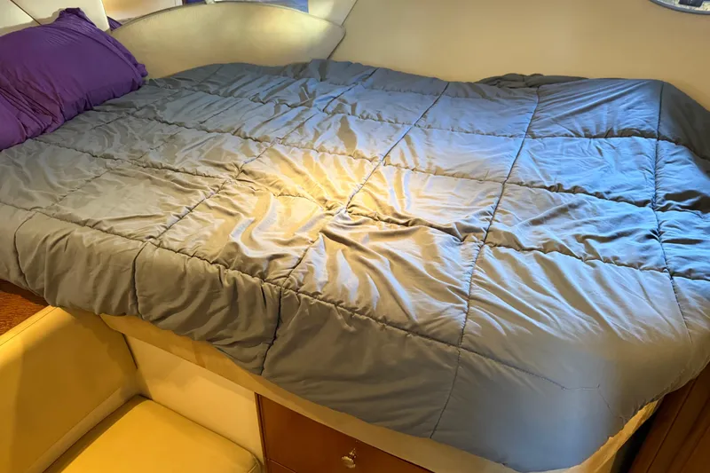  Yacht Photos Pics Cozy bed inside a 2005 Meridian 341 Sedan yacht cabin with purple pillows.