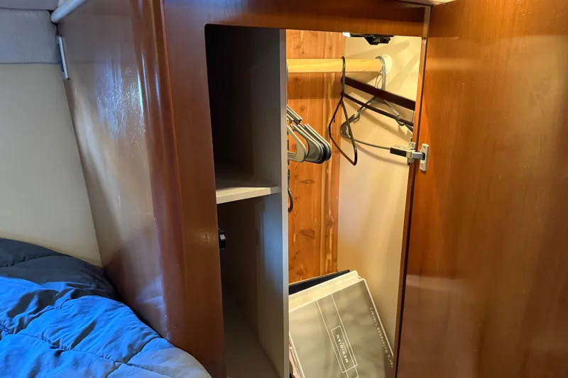  Yacht Photos Pics Wooden closet interior on a 2005 Meridian 341 Sedan yacht, featuring hangers and storage space.