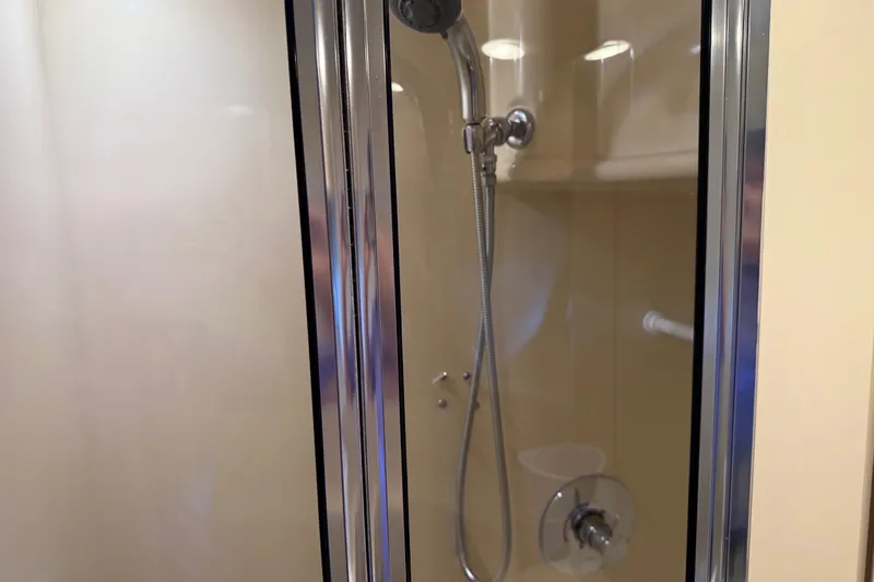  Yacht Photos Pics Shower area inside a 2005 Meridian 341 Sedan yacht, featuring a glass door and chrome fixtures.