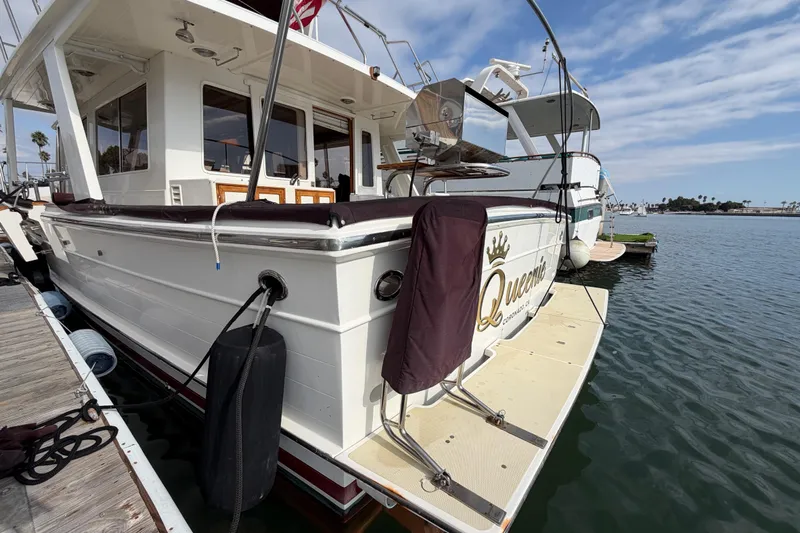 Queenie Yacht Photos Pics 1988 Offshore Yachts 48 Sedan docked, featuring spacious deck and elegant design.