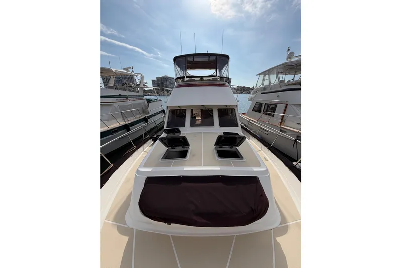 Queenie Yacht Photos Pics 1988 Offshore Yachts 48 Sedan docked, showcasing sleek design and spacious deck.