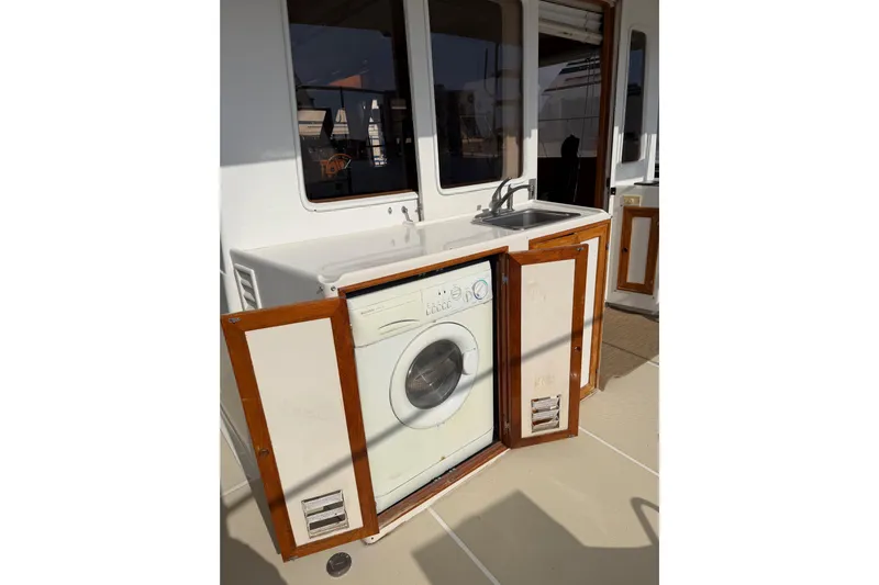 Queenie Yacht Photos Pics Laundry area with washing machine and sink on 1988 Offshore Yachts 48 Sedan.