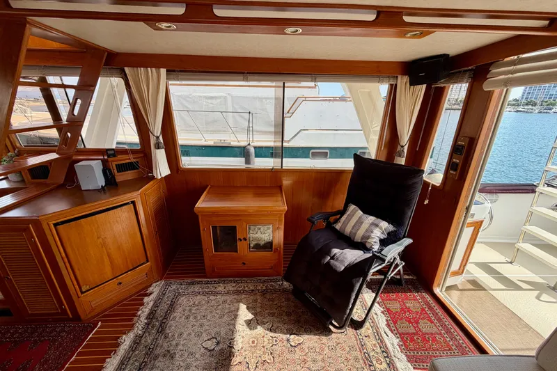 Queenie Yacht Photos Pics Interior of 1988 Offshore Yachts 48 Sedan with wooden furnishings and a reclining chair.