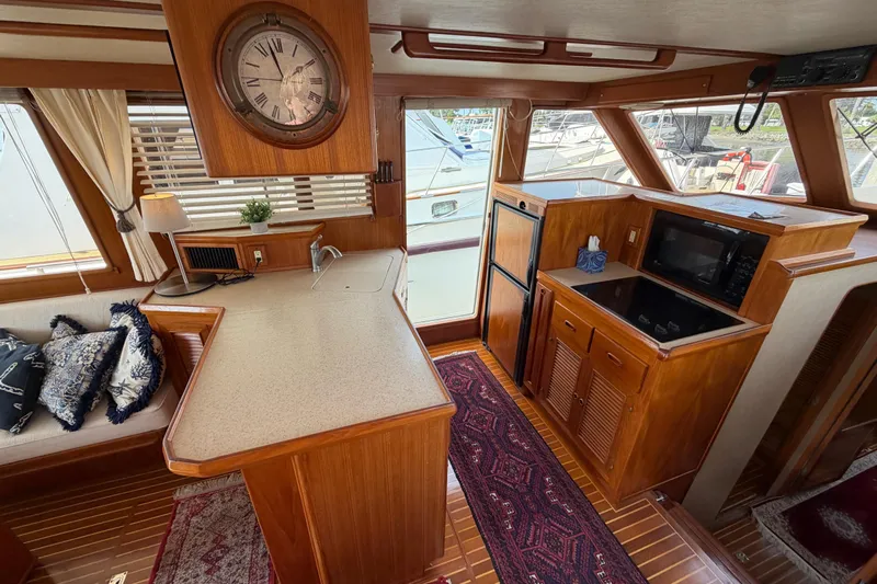 Queenie Yacht Photos Pics Interior of 1988 Offshore Yachts 48 Sedan with kitchen and seating area.