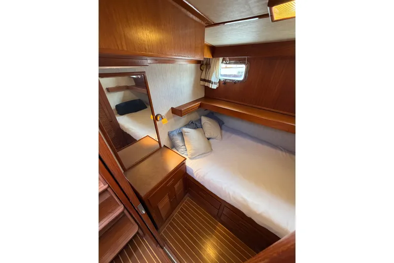 Queenie Yacht Photos Pics Cozy cabin interior of 1988 Offshore Yachts 48 Sedan with wood finish and bedding.