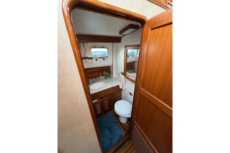 Queenie Yacht Photos Pics Bathroom interior of 1988 Offshore Yachts 48 Sedan, featuring wood accents and nautical decor.