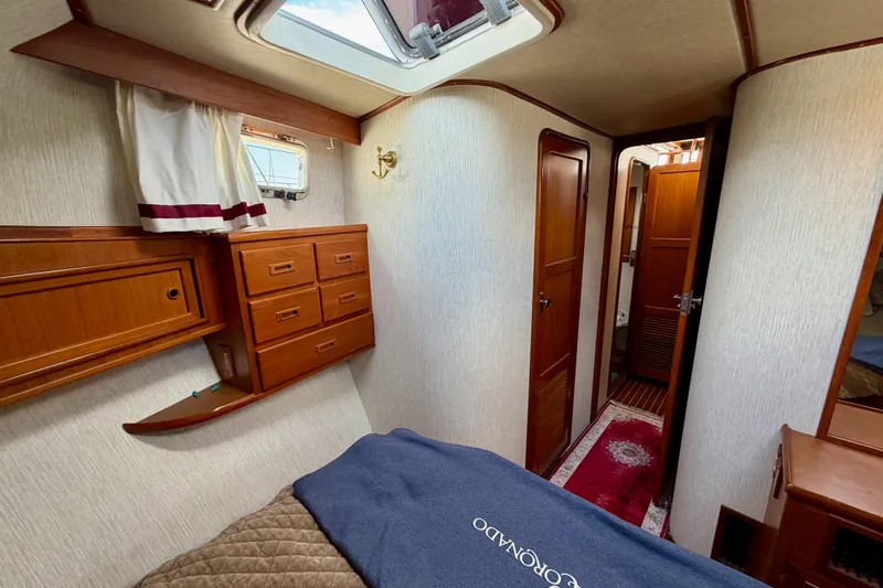 Queenie Yacht Photos Pics Interior of 1988 Offshore Yachts 48 Sedan, featuring wood cabinetry and cozy sleeping quarters.