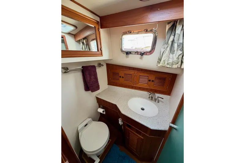 Queenie Yacht Photos Pics 1988 Offshore Yachts 48 Sedan bathroom with sink, toilet, and wooden cabinetry.