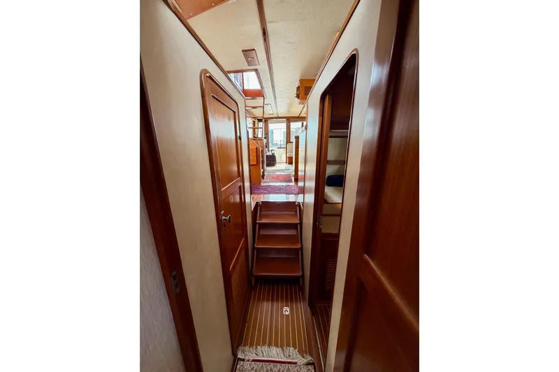Queenie Yacht Photos Pics Interior hallway of 1988 Offshore Yachts 48 Sedan, featuring wooden doors and steps.