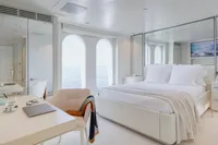 Luxurious yacht bedroom with ocean view, modern decor, and elegant furnishings, Austal Displacement 2007.