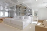 Luxurious yacht bedroom with modern decor, featuring a large bed and elegant furnishings.