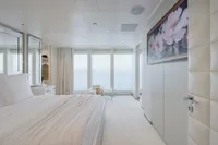 Luxurious yacht bedroom with ocean view, featuring elegant decor and floral artwork, Austal Displacement 2007.