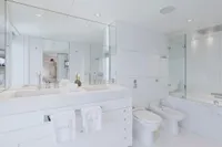 Luxurious white bathroom with dual sinks, mirrors, and modern fixtures on Austal Displacement yacht, 2007.