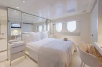 Luxurious yacht bedroom with elegant decor, featuring a comfortable bed and large windows.