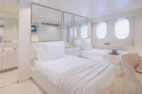 Luxurious yacht cabin with twin beds, mirrors, and porthole windows, Austal Displacement 2007 model.