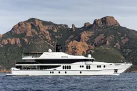 Luxurious 2007 Austal Displacement yacht cruising near rugged coastal cliffs.