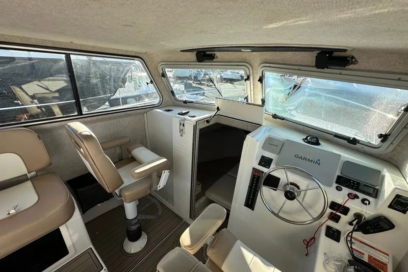 Fortuna Yacht Photos Pics 2019 Parker 2820 XLD Sport Cabin interior with helm, seating, and Garmin navigation system.