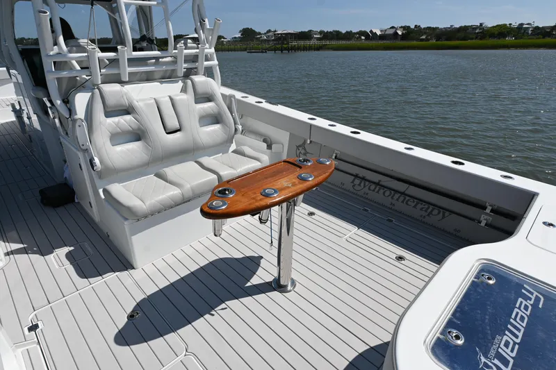  Yacht Photos Pics 2021 Freeman 37VH boat interior with white seating and wooden table on a calm water backdrop.
