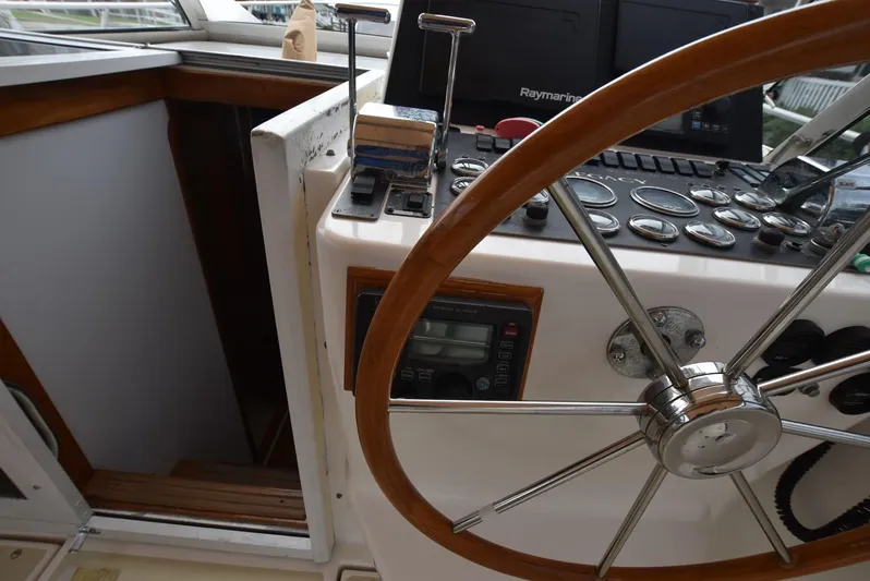 Don't Blink Yacht Photos Pics 1999 Legacy 34 Express boat helm with wooden steering wheel and control panel.