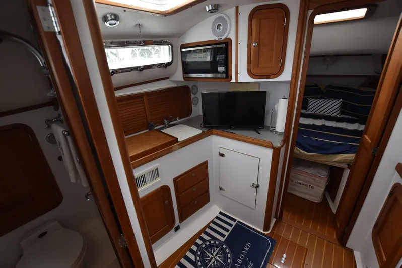 Don't Blink Yacht Photos Pics Interior of 1999 Legacy 34 Express boat with kitchenette and cozy sleeping area.