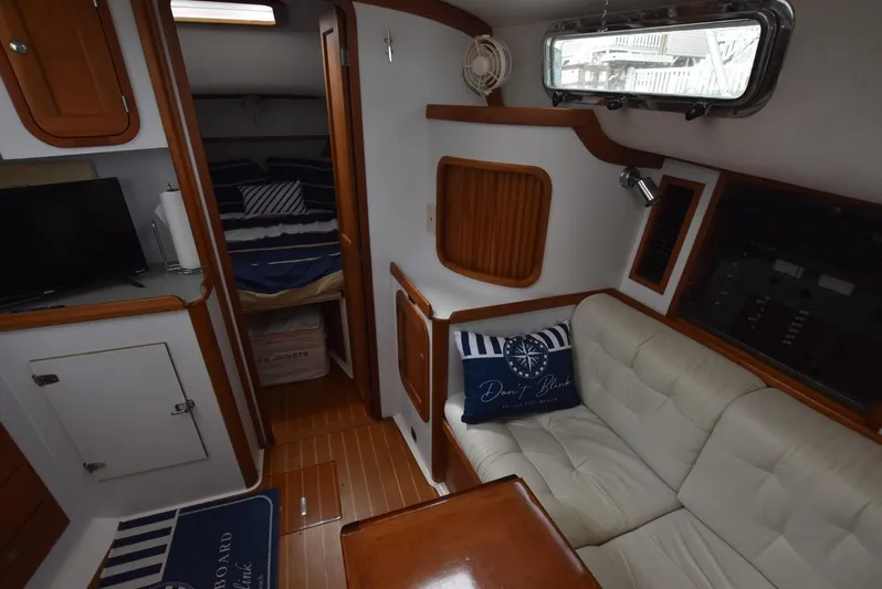 Don't Blink Yacht Photos Pics 1999 Legacy 34 Express cabin interior with sofa, table, and cozy sleeping area.