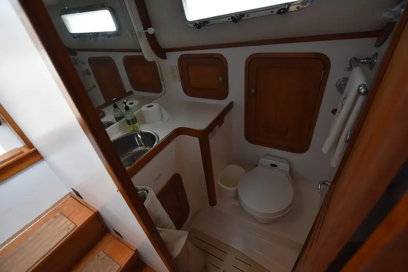 Don't Blink Yacht Photos Pics 1999 Legacy 34 Express yacht bathroom with wooden cabinets and compact design.