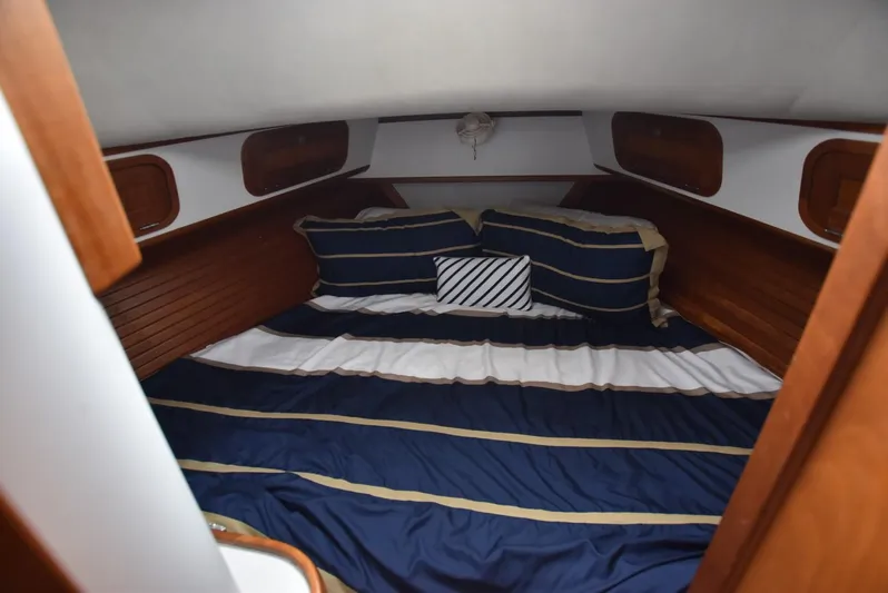 Don't Blink Yacht Photos Pics Cozy cabin interior of 1999 Legacy 34 Express with striped bedding.