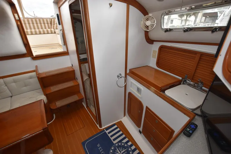Don't Blink Yacht Photos Pics 1999 Legacy 34 Express yacht interior with wood accents and compact kitchen area.