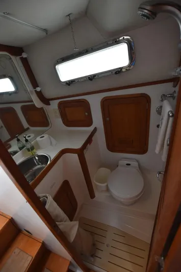 Don't Blink Yacht Photos Pics 1999 Legacy 34 Express boat bathroom with wooden accents and compact design.